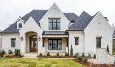 a large white brick house with two story windows