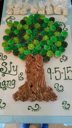 there is a cake made to look like a tree with green leaves and buttons on it