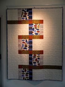 a quilt hanging on the wall in a room