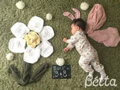 a baby laying on the floor next to some diapers