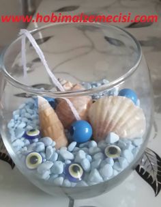 a glass bowl filled with blue rocks and seashells