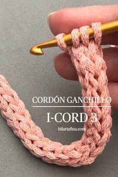 someone is crocheting the end of a piece of yarn with a gold needle