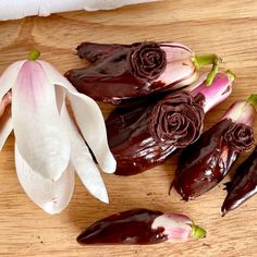 several pieces of chocolate with flowers on a wooden surface