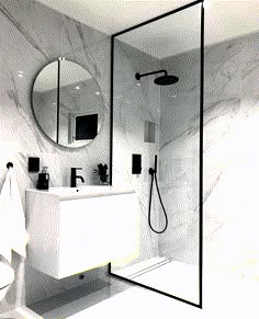 a white bathroom with marble walls and floor