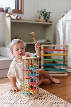 a toddler playing with a toy tower on the floor