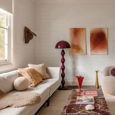 a living room with two couches and a lamp in the corner on the table