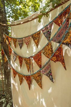 a group of colorful flags hanging from a tree