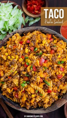 A bowl of taco pasta salad with garnishes of lettuce, tomato, and dressing positioned off the side. Meat Lovers Pasta Salad, Different Types Of Pasta Salads, What Goes With Pasta Salad, Pasta Taco Salad Recipe, Pasta And Lettuce Salad, Cheeseburger Pasta Salad, Taco Pasta Salad Recipes, Spiral Pasta Recipes, Pasta Taco Salad