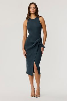 Stay effortlessly chic with the Abigail Sleeveless Sarong Skirt Knit Dress. This midi dress combines style and comfort with its sleek sleeveless racerback top and flattering wrap skirt, which drapes elegantly. Ideal for layering with sweaters or blazers, the knit dress can easily transition between seasons, making it a versatile option for travel or everyday wear. Pair it with boots or sandals to complete your look, no matter your destination. Perfect for casual outings or more polished occasion Skirt Knit, Sarong Dress, Sarong Skirt, Racerback Top, Sleeveless Knit, Knit Midi, Knit Midi Dress, Dark Teal, Sarong