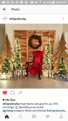 a room decorated for christmas with trees and lights on the wall, and a red chair in front of it