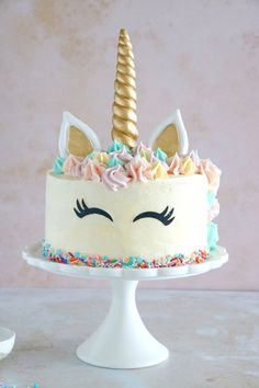 a cake decorated with sprinkles and a unicorn's horn on top