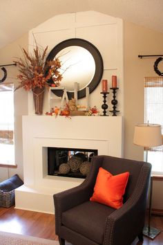 a living room filled with furniture and a fire place under a mirror on the wall