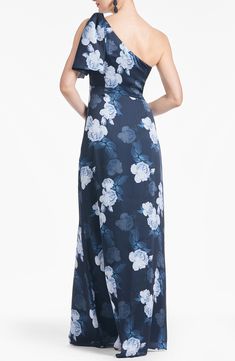 a woman in a blue and white floral print one - shoulder dress, back view