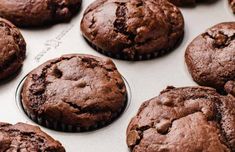 chocolate muffins sitting on top of a baking sheet