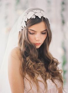 a woman wearing a veil with flowers on it