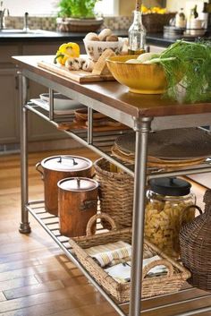 a kitchen island with baskets and food on it in front of a counter top area