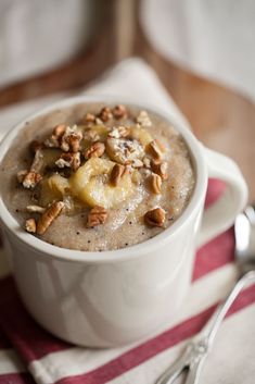 a white bowl filled with oatmeal and nuts on top of a striped napkin