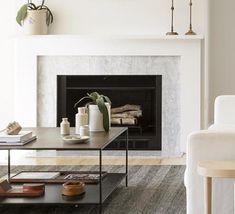 a living room with white furniture and a fireplace