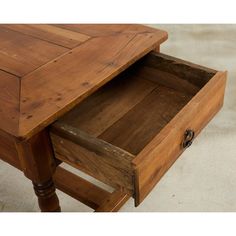 a wooden table with two drawers on the bottom and one drawer open to show what's inside