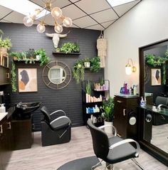 a hair salon with chairs and plants on the walls, mirrors above them and lights hanging from the ceiling