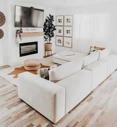 a living room filled with furniture and a flat screen tv mounted on the wall above a fire place