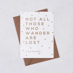 a card with the words not all those who wander are lost printed on it in gold foil