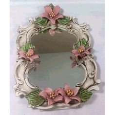 a mirror with pink flowers and green leaves on it