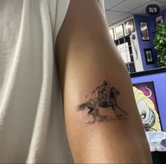 a man with a tattoo on his arm riding a horse in the middle of an office