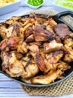 a skillet filled with meat sitting on top of a table