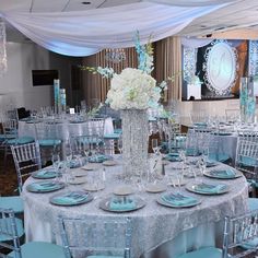 the table is set with blue and white plates, napkins, silverware, and centerpieces