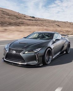 a gray sports car driving down the road