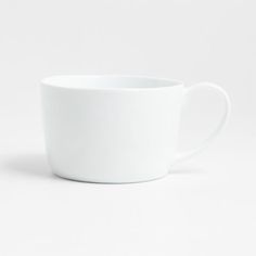 a white coffee cup sitting on top of a table