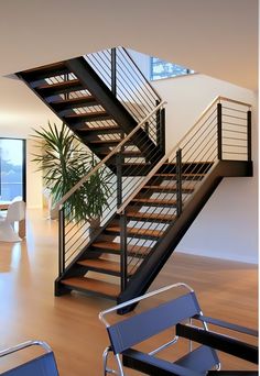 there is a stair case in the living room next to a table and chairs on the floor