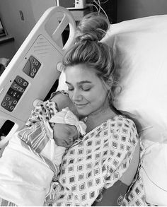 a woman laying in a hospital bed holding a baby