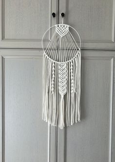 a white macrame hanging on the side of a door