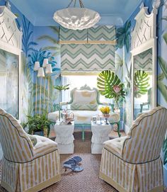 a living room filled with furniture and walls covered in palm leaves painted on the walls