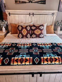 a bed with two pillows on top of it next to a dresser and other items