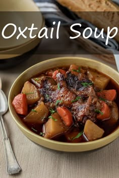 a bowl of stew with carrots, potatoes and meat on a table next to bread