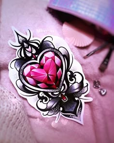 a close up of a heart shaped sticker on a pink shirt with scissors and other items