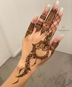 a woman's hand with henna tattoos on it