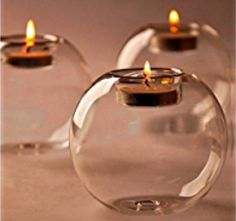 three clear glass vases with candles inside them