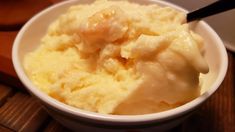 a white bowl filled with mashed potatoes on top of a wooden table