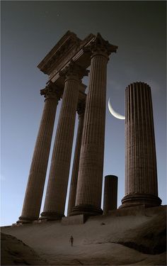 the moon is setting behind some ancient columns