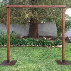 a wooden arbor in the middle of a yard