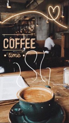 a cup of coffee sitting on top of a wooden table next to a menu with the words coffee time