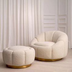 a white chair and ottoman sitting on top of a wooden floor