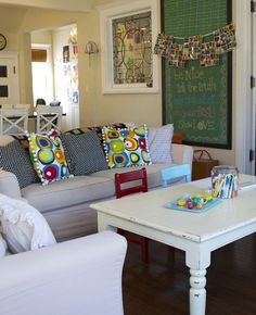 a living room filled with furniture and a chalkboard on the wall above it's door