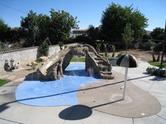 an outdoor play area with rocks and water features