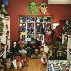 a room filled with lots of halloween decorations and masks on the walls, including fake heads