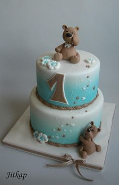 there is a blue and white cake with two bears on the top one has a brown teddy bear sitting on it